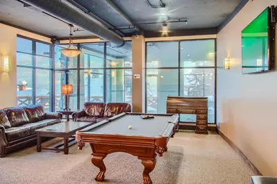 a living room with a pool table and a piano at Stonegate Resort Unit B401 in Big White