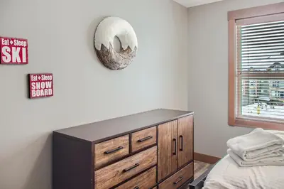 a bedroom with a bed and a dresser at Stonegate Resort Unit B204 in Big White