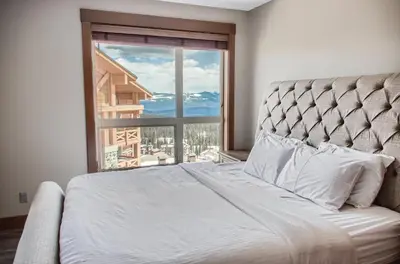 a bedroom with a bed and a large window at Stonegate Resort Unit B208 in Big White