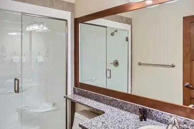 a bathroom with a shower and a sink and a mirror at Stonegate Resort Unit A402 in Big White