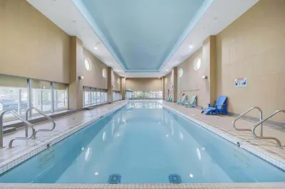 a large indoor swimming pool with blue water at Elevated Elegance in Calgary