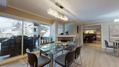 a dining room with a glass table and chairs at LAGOONS 20 Village location Rare 5BDR Condo With Private Hot Tub in Whistler