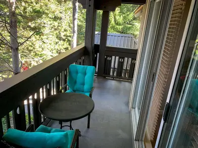 a balcony with a table and chairs on a porch at LAGOONS 20 Village location Rare 5BDR Condo With Private Hot Tub in Whistler
