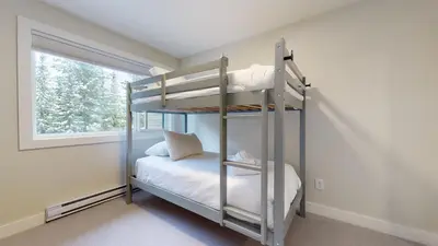 a bedroom with two bunk beds and a window at TELEMARK 25 Ski-In Ski-Out Access Steps To Ski Lifts Renovated Townhome in Whistler