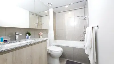 a bathroom with a toilet and a tub and a sink at Downtown Center Silverstone Tower I and II Home in Vancouver in Vancouver