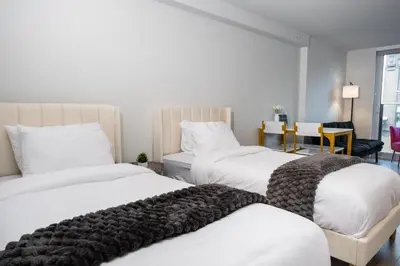 a bedroom with three beds with white sheets at Downtown Center Silverstone Tower I and II Home in Vancouver in Vancouver