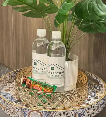 two bottles of water on a table with a plant at Downtown Center Silverstone Tower I and II Home in Vancouver in Vancouver