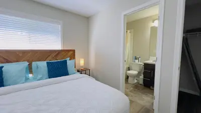 a bedroom with a large bed and a bathroom at Sylvan Lake Retreat I 122A Hinshaw Drive, Sylvan Lake in Sylvan Lake