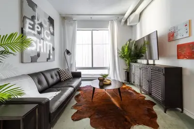 a living room with a leather couch and a table at Chic & Cozy Loft near Rogers Place, LRT, Jasper Ave in Edmonton