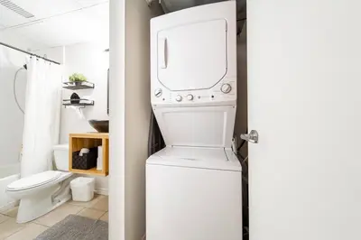 a white washer and dryer in a bathroom at Chic & Cozy Loft near Rogers Place, LRT, Jasper Ave in Edmonton