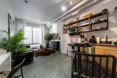 a kitchen with a counter and some chairs in a room at Chic & Cozy Loft near Rogers Place, LRT, Jasper Ave in Edmonton