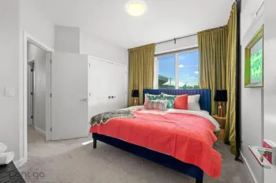 a bedroom with a red bed and a window at Jungle House, AirCon, Sleeps 8, Near WEM & DT! in Edmonton