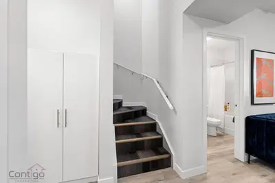 a white hallway with a staircase in a house at Jungle House, AirCon, Sleeps 8, Near WEM & DT! in Edmonton