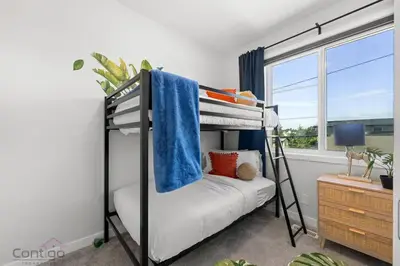 a bedroom with a bunk bed and a window at Urban Jungle Getaway, AirCon, 10min to DT & WEM! in Edmonton