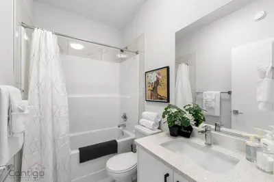 a white bathroom with a toilet and a sink at Urban Jungle Getaway, AirCon, 10min to DT & WEM! in Edmonton