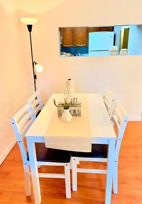 a white dining room table with white chairs at Private Room In The Heart Of The City in Vancouver