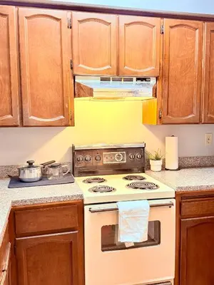 a kitchen with a stove and wooden cabinets at Private Room In The Heart Of The City in Vancouver