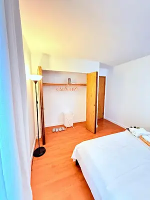 a bedroom with a white bed and a wooden floor at Private Room In The Heart Of The City in Vancouver