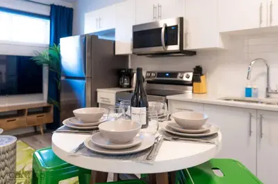 a kitchen with a table with plates and a bottle of wine at The Den, Centrally Located Suite, King Bed, WiFi! in Edmonton