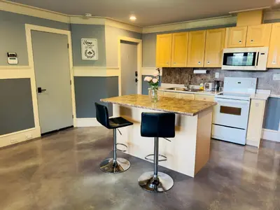 a kitchen with a large island with two bar stools at Unitrip Queen bed Room 2 in Richmond