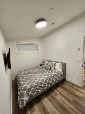 a bedroom with a bed in a room at 2BR Detached Guesthouse - Free Parking -10 mins to YVR & Downtown in Vancouver