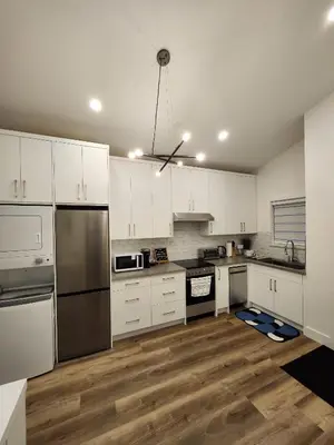 a kitchen with white cabinets and stainless steel appliances at 2BR Detached Guesthouse - Free Parking -10 mins to YVR & Downtown in Vancouver