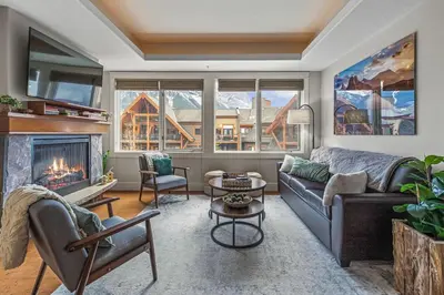 a living room with a couch and a fireplace at Luxury Rockies Retreat 1BR with Views in Canmore