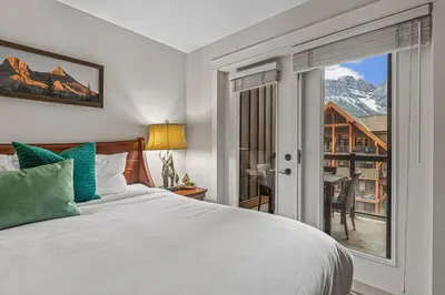 a bedroom with a bed and a window with a view at Luxury Rockies Retreat 1BR with Views in Canmore