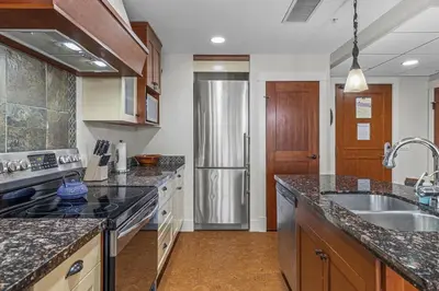 a kitchen with a sink and a refrigerator at Luxury Rockies Retreat 1BR with Views in Canmore