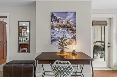 a dining room with a table and a picture on the wall at Luxury Rockies Retreat 1BR with Views in Canmore