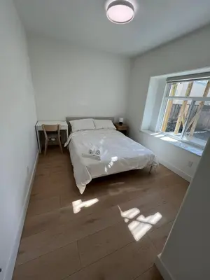 a white bedroom with a bed and a window at Waverley Guest Room in Vancouver in Vancouver