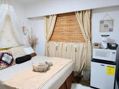 a room with a bed with a microwave and a window at Cozy Boho Room at the Heart of Vancouver! Private Parking, Self Check-in & just 4 mins to Metrotown! in Burnaby