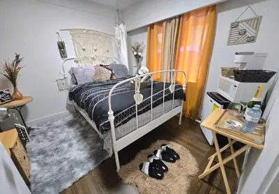 a bedroom with a bed with a blue comforter at Cozy Boho Room at the Heart of Vancouver! Private Parking, Self Check-in & just 4 mins to Metrotown! in Burnaby