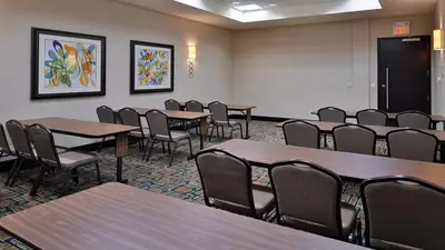 a conference room with tables and chairs in it at Holiday Inn Hotel & Suites Edmonton Airport Conference Centre by IHG in Nisku