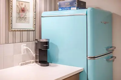a blue refrigerator sitting in a kitchen next to a counter at Luxe Suite close to Spruce Meadows in Priddis