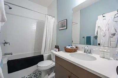 a white bathroom with a sink and a toilet at Luxe Suite close to Spruce Meadows in Priddis