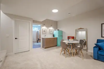 a kitchen and dining room with a table and a blue refrigerator at Luxe Suite close to Spruce Meadows in Priddis