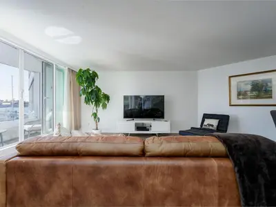 a living room with a large brown leather couch at Coastal Charm - min 3-Day Stay Breathtaking Views with Work Desk by Victoria Prime! in Victoria