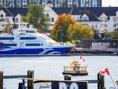 a boat and a small boat in the water at Coastal Charm - min 3-Day Stay Breathtaking Views with Work Desk by Victoria Prime! in Victoria