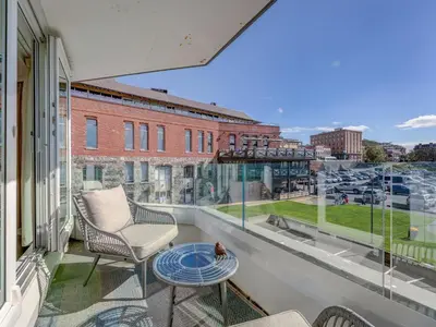 a balcony with two chairs and a table and a window at Coastal Charm - min 3-Day Stay Breathtaking Views with Work Desk by Victoria Prime! in Victoria