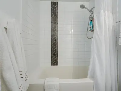 a white bathroom with a shower and a bath tub at The Bohemian, min 30-Day Stay with Breathtaking Views and Home Office by Victoria Prime! in Victoria