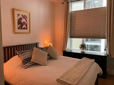 a bedroom with a bed with two pillows and a window at The Bohemian, min 30-Day Stay with Breathtaking Views and Home Office by Victoria Prime! in Victoria