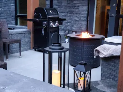 a grill with a fire in the middle of a patio at Le Bucheron Stunning Spring Creek Luxury condo in Canmore