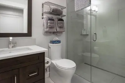 a bathroom with a toilet and a glass shower at Le Bucheron Stunning Spring Creek Luxury condo in Canmore