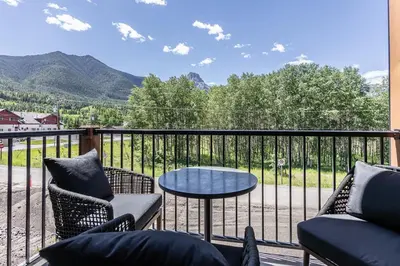 a balcony with chairs and a table and a view at Serenity at Sparrowhawk Lodge Brand New 2Bd 2Ba in Dead Man's Flats