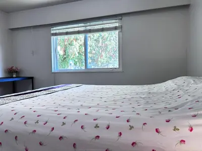 a bedroom with a bed with flowers on it at Upper floor suite with Garden view near SFU & Skytrain in Coquitlam