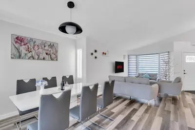 a living room with a couch and a table and chairs at ModernOasis with AC&MovieRoom close to Downtown15' Banff 60' in Calgary