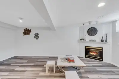 a living room with a fireplace and a table at ModernOasis with AC&MovieRoom close to Downtown15' Banff 60' in Calgary