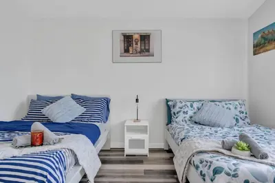 a bedroom with two beds with blue and white sheets at ModernOasis with AC&MovieRoom close to Downtown15' Banff 60' in Calgary