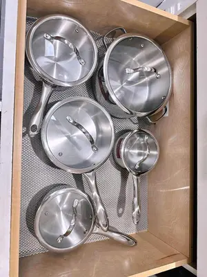 a wooden box filled with silver dishes and spoons at The warm and lovely coach home in Vancouver